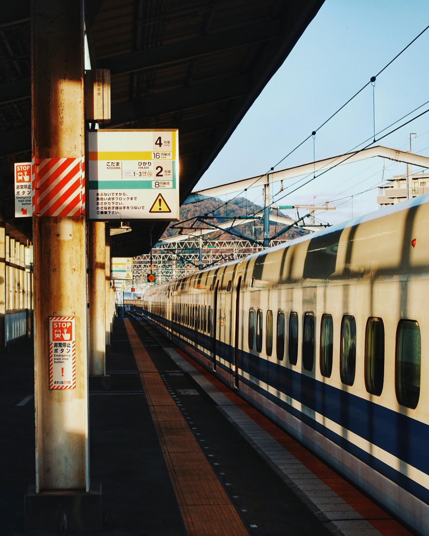 A Shinkansen waiting at a sunny platform in Japan